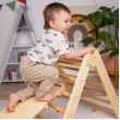 Das Pikler-Dreieck hilft Kindern, ihre motorischen Grenzen sicher zu entdecken und weiterzuentwickeln.