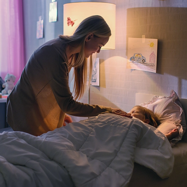 Mutter legt ihr Kind ins Bett