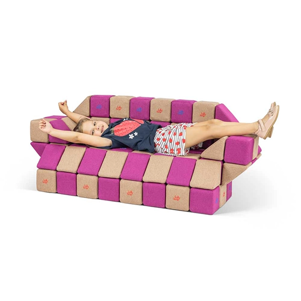 Mädchen liegt auf einem Sofa aus JollyHeap Magnetbausteinen
