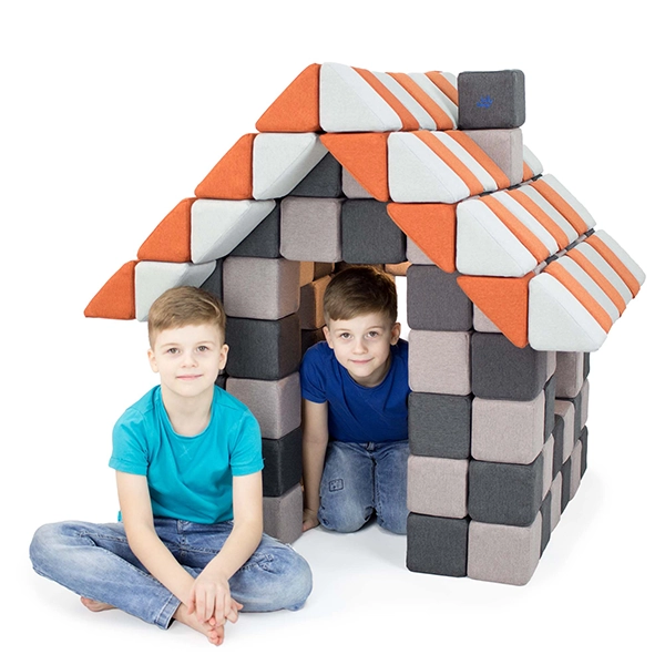 Jungen sitzen im Haus aus JollyHeap Magnetbausteinen